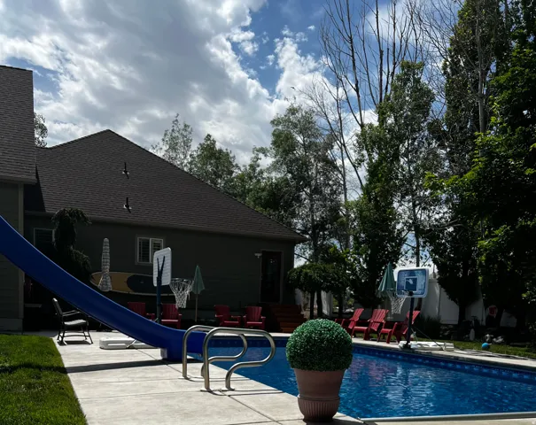 View of swimming pool featuring a water slide and patio surround