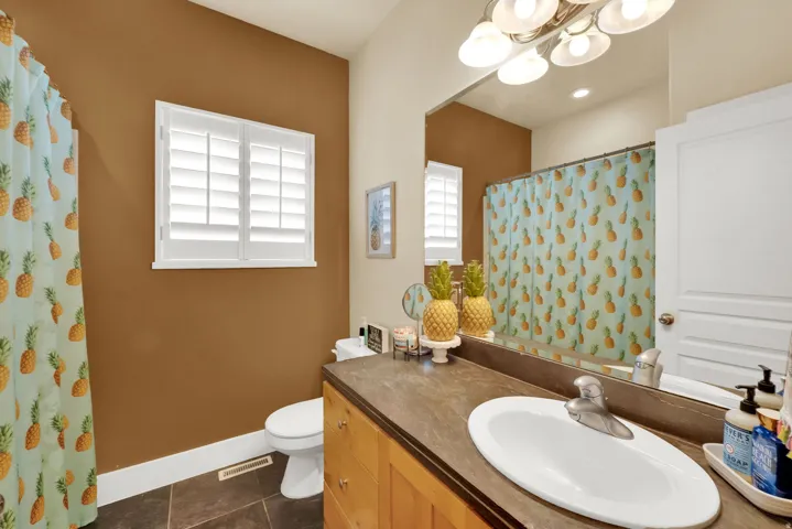 Bathroom featuring vanity, curtained shower, a chandelier, and dark tile patterned floors