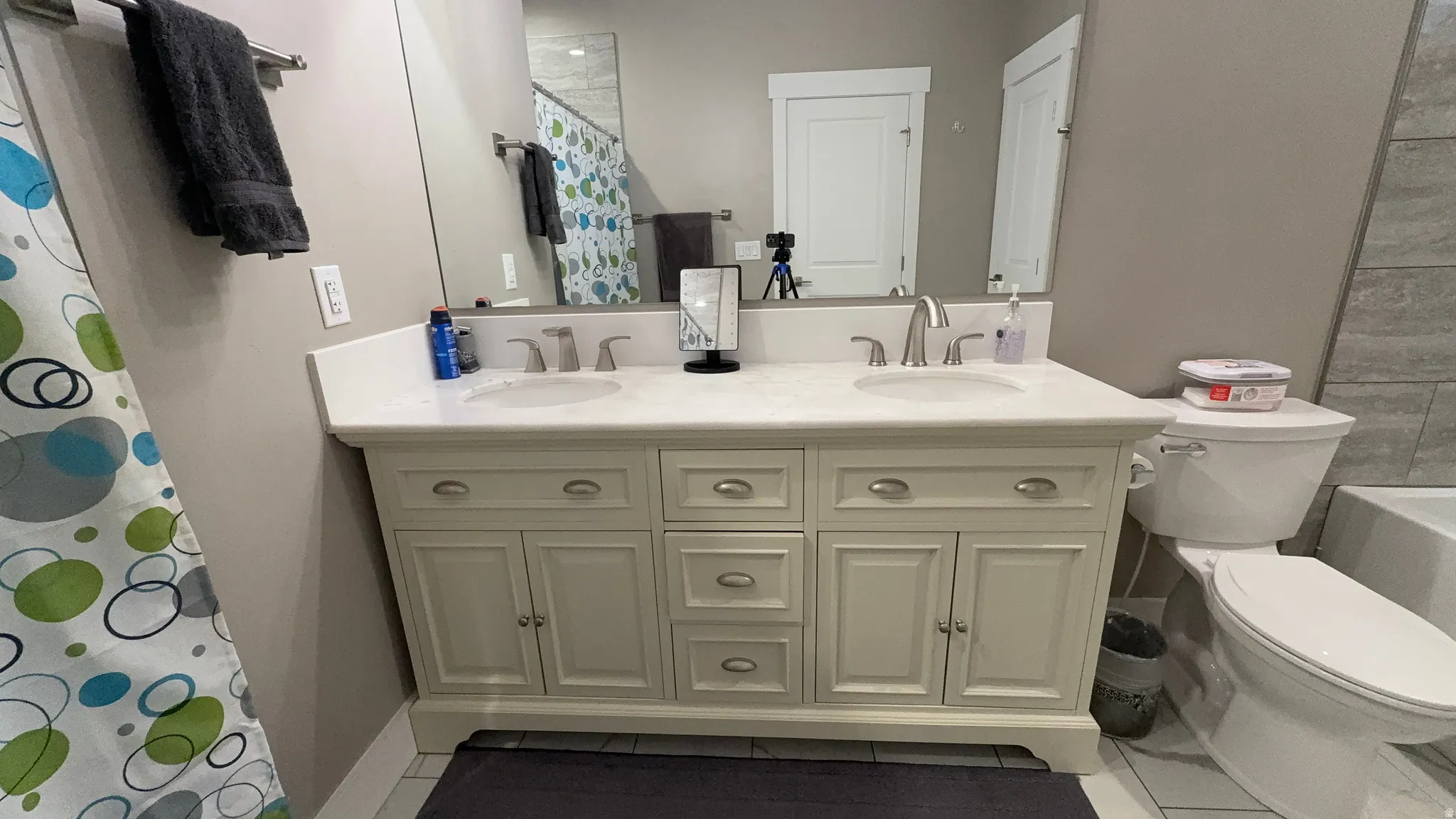 Bathroom featuring double vanity and light tile patterned flooring