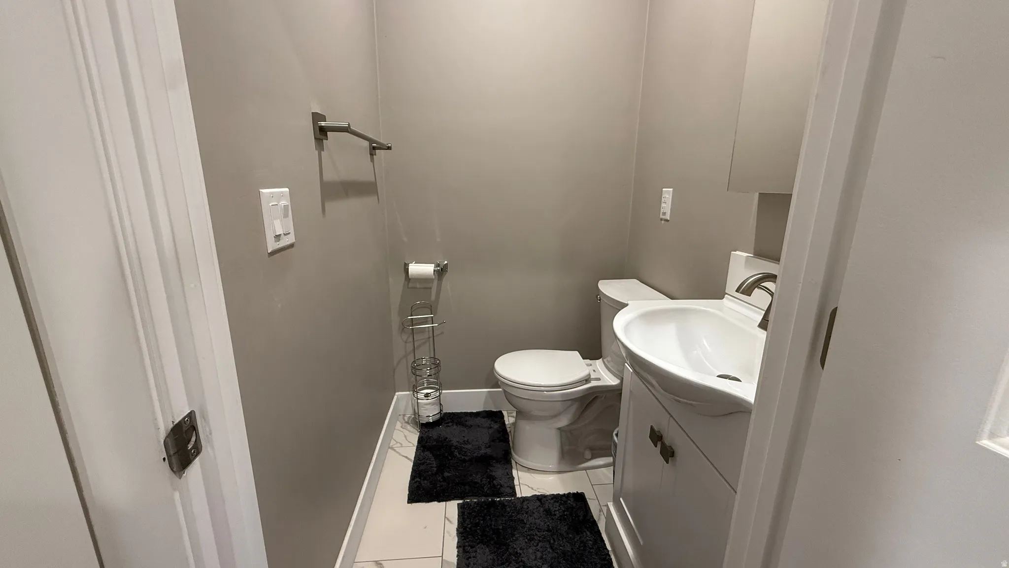 Half bathroom with vanity and light tile patterned floors