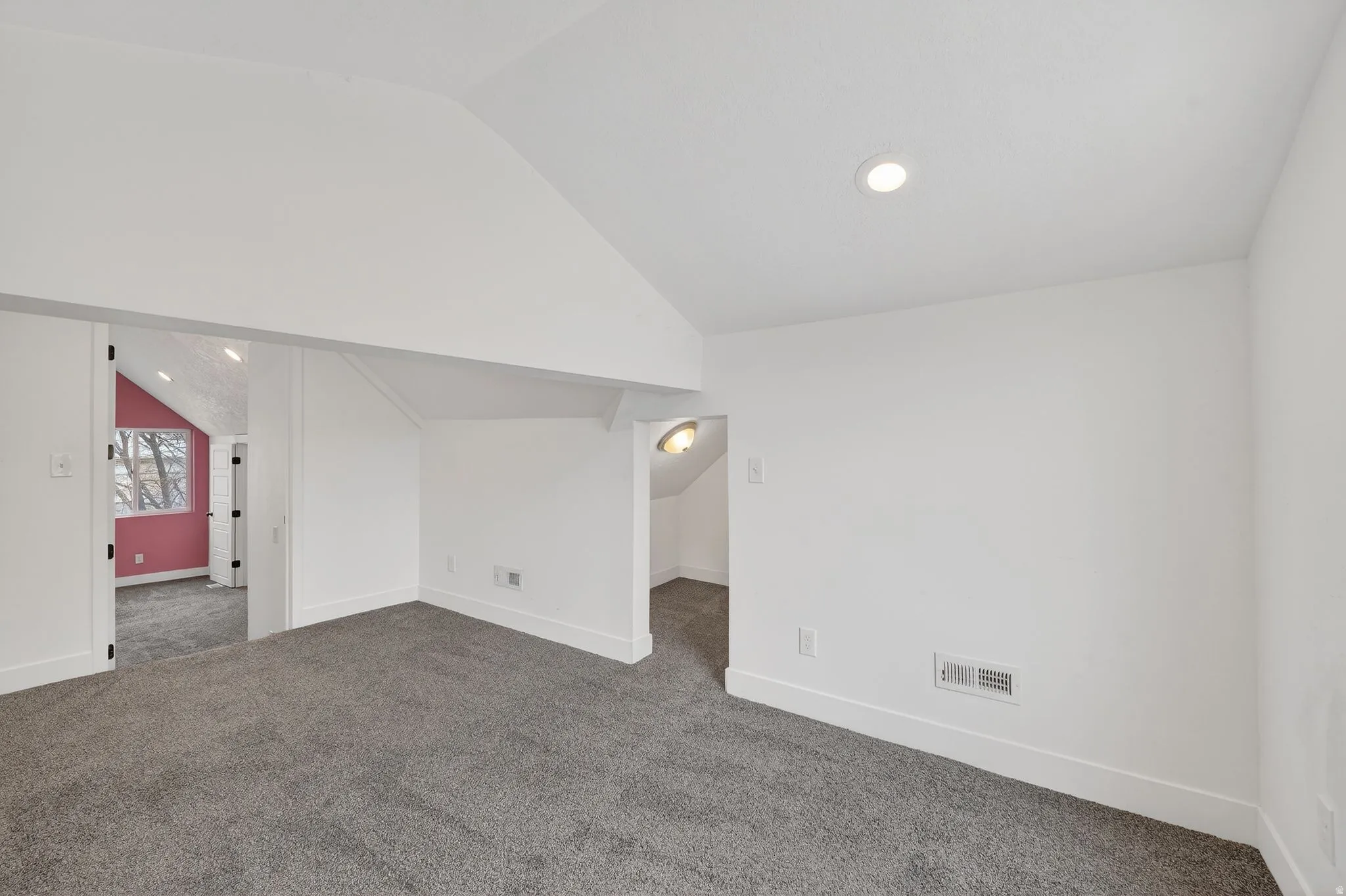 Additional living space featuring lofted ceiling, dark colored carpet, and recessed lighting