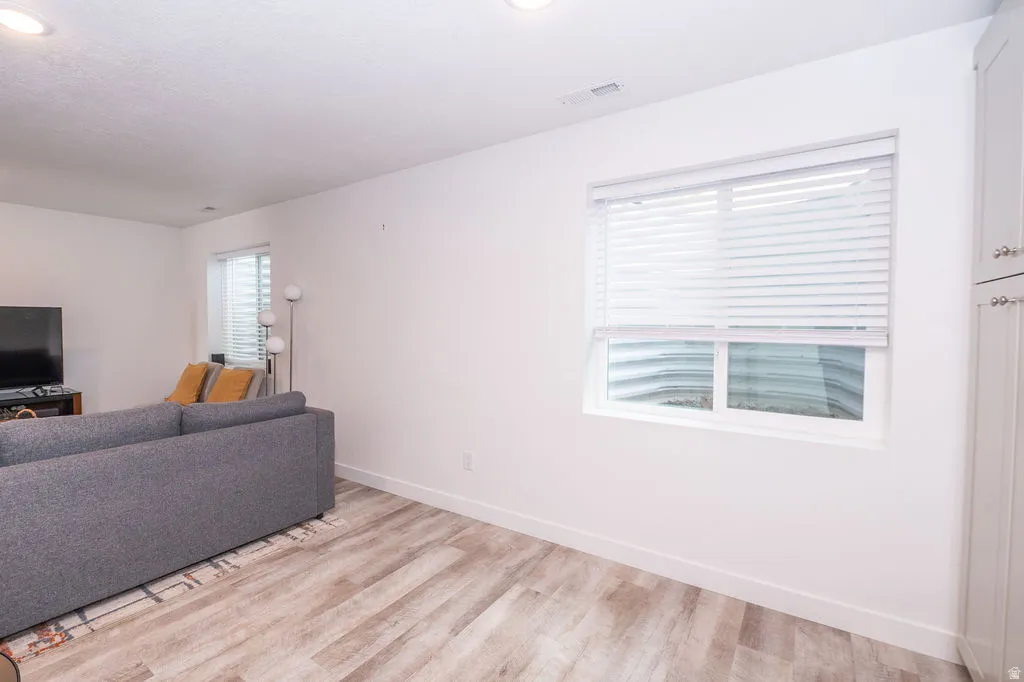 Living area featuring light wood finished floors and recessed lighting
