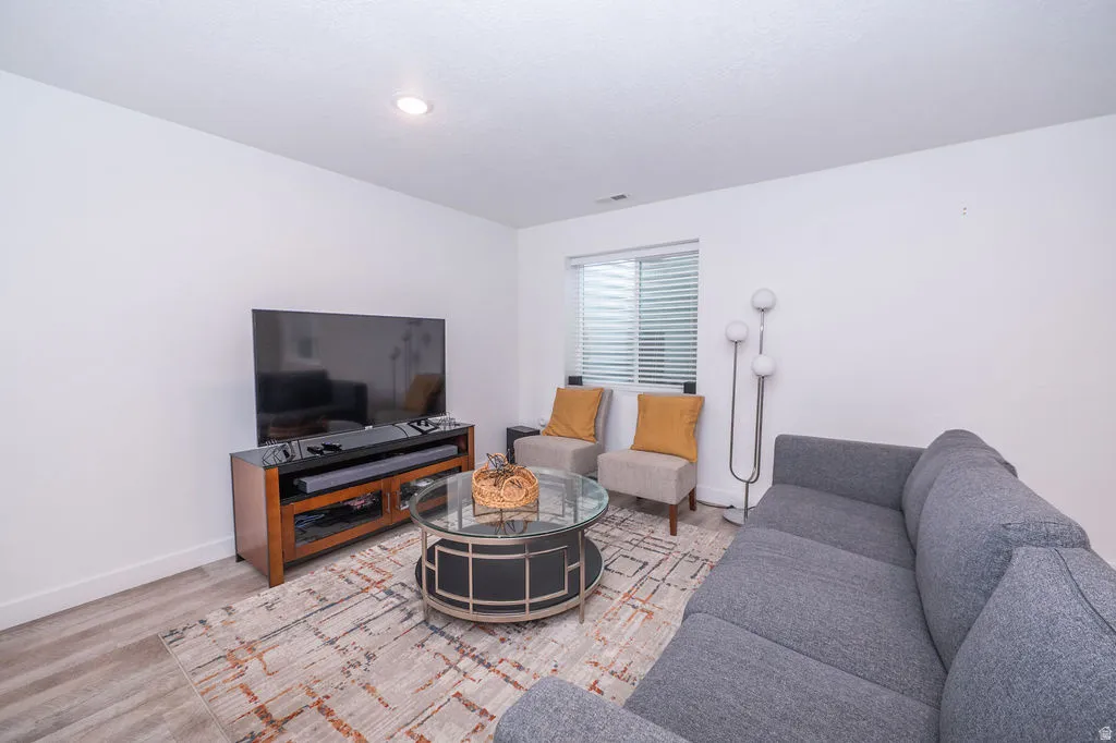 Living room with baseboards and light wood-style floors