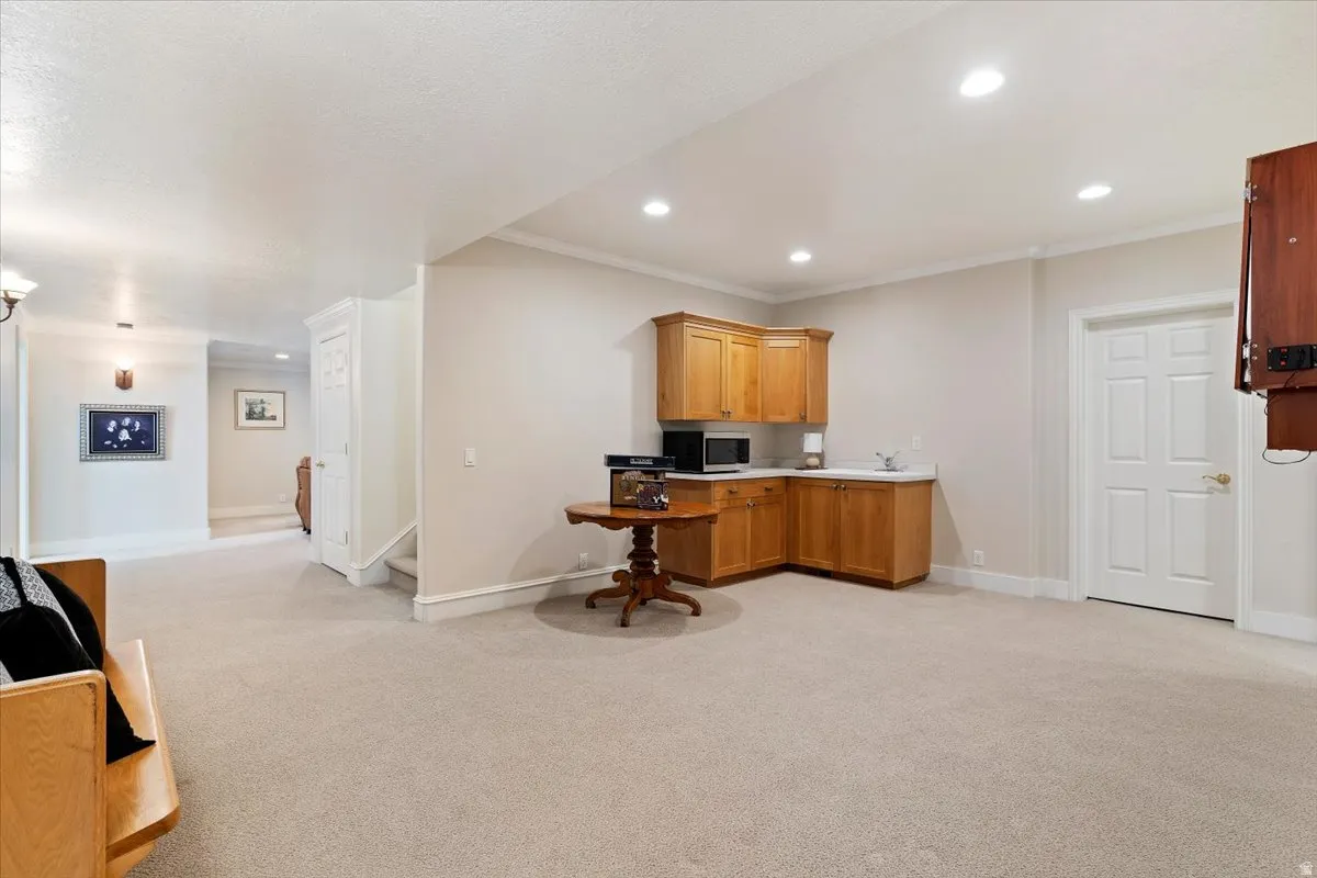 Office space with light carpet, ornamental molding, and recessed lighting