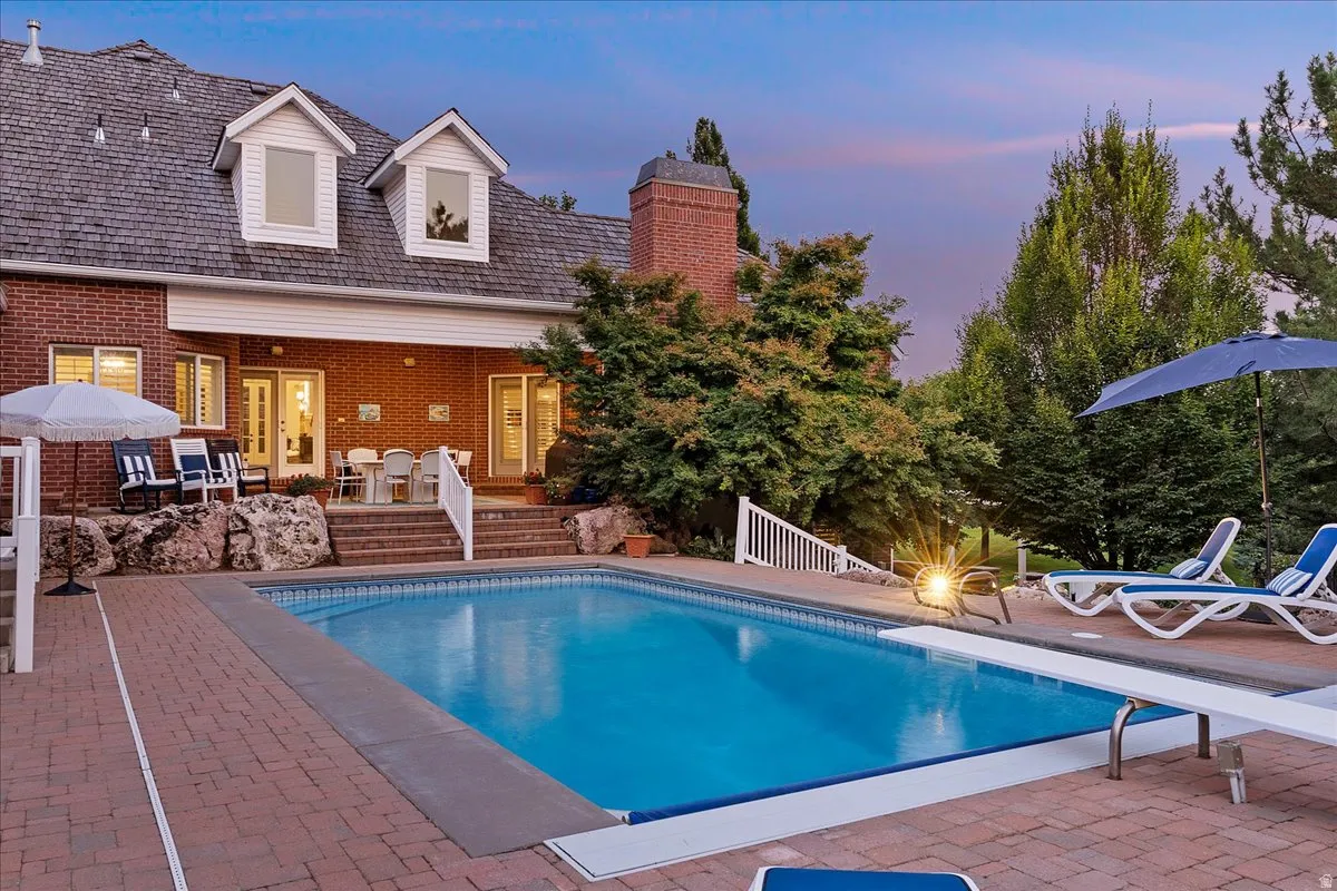 Swimming pool with a patio area and a diving board