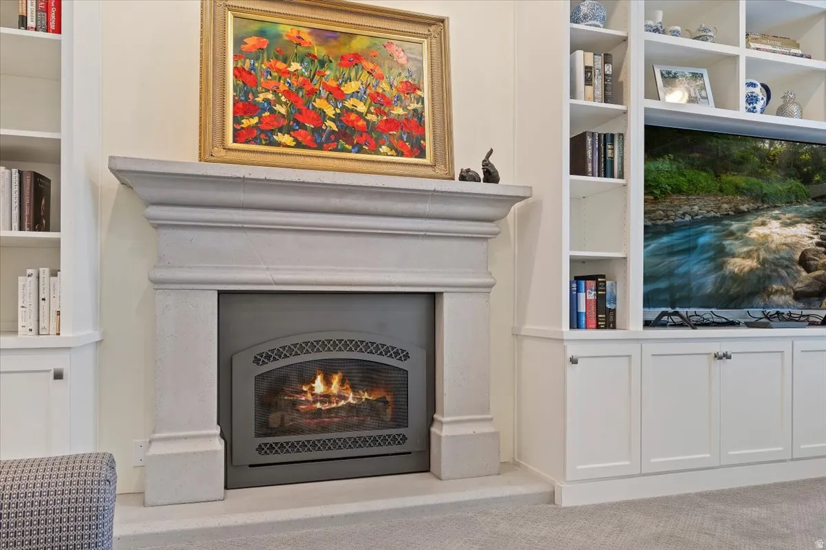 Detailed view of a warm lit fireplace and carpet