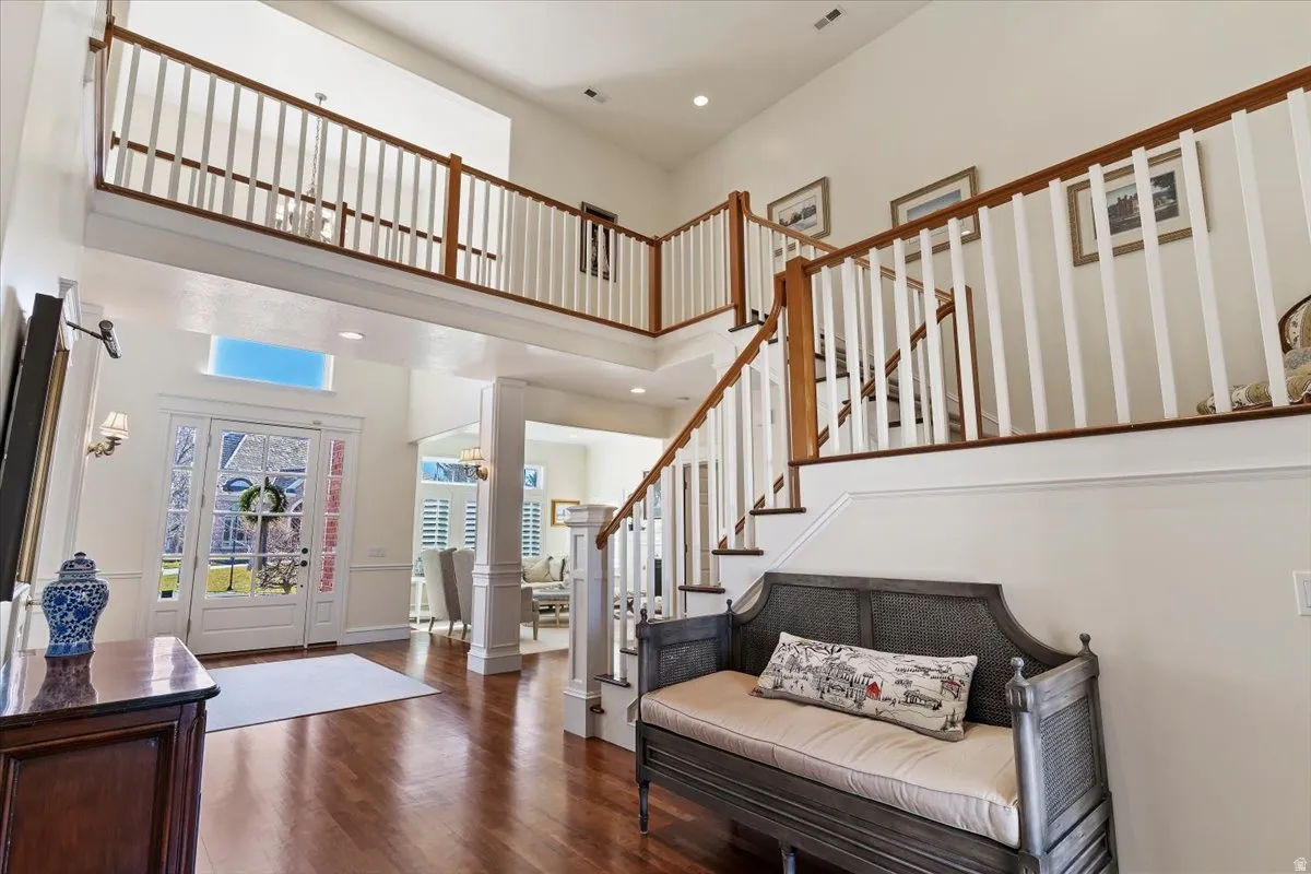 Entryway with recessed lighting, dark wood-style flooring, ornate columns, and a high ceiling