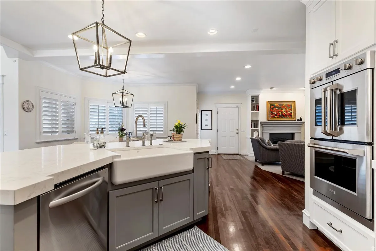 Kitchen with stainless steel appliances, light stone counters, open floor plan, a fireplace, and dark wood-style floors