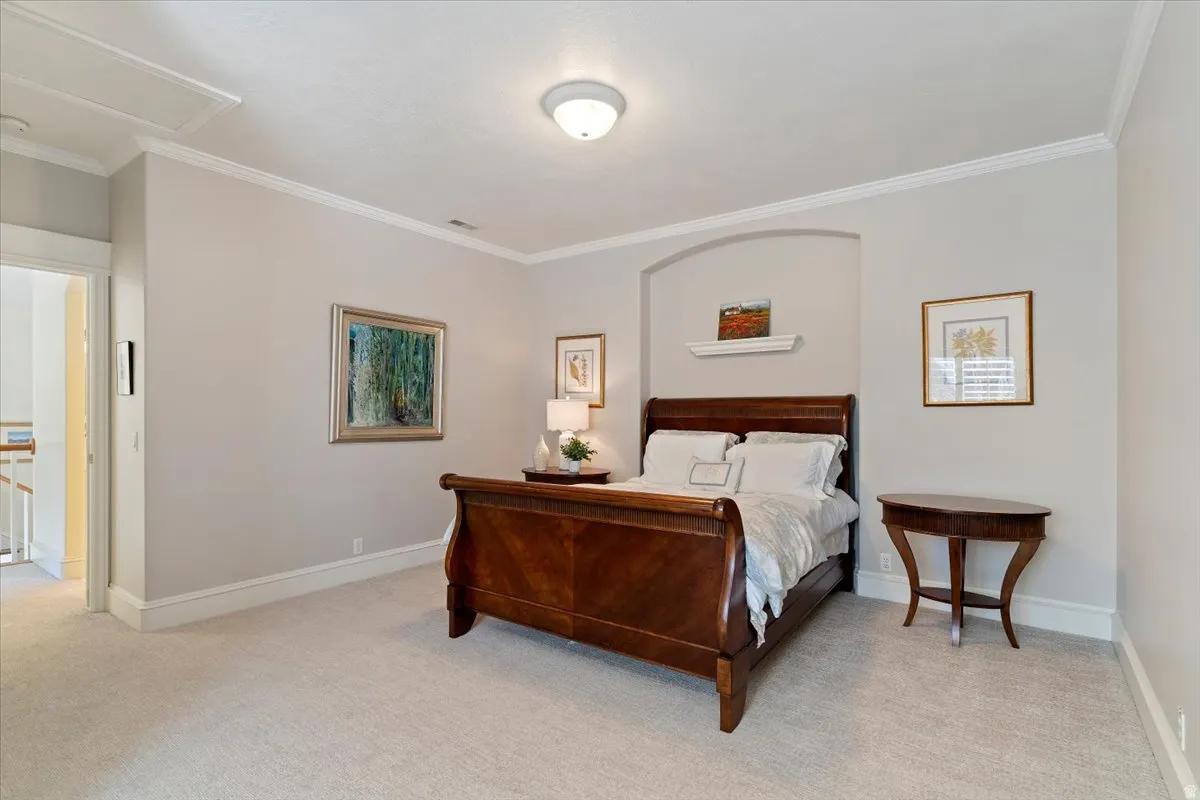 Bedroom featuring crown molding and light colored carpet