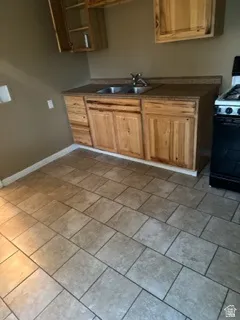 Kitchen featuring black range with gas stovetop and dark countertops
