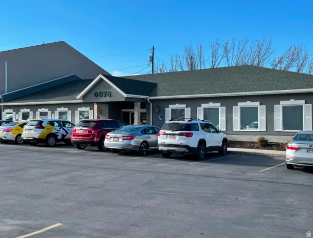 View of building exterior featuring uncovered parking