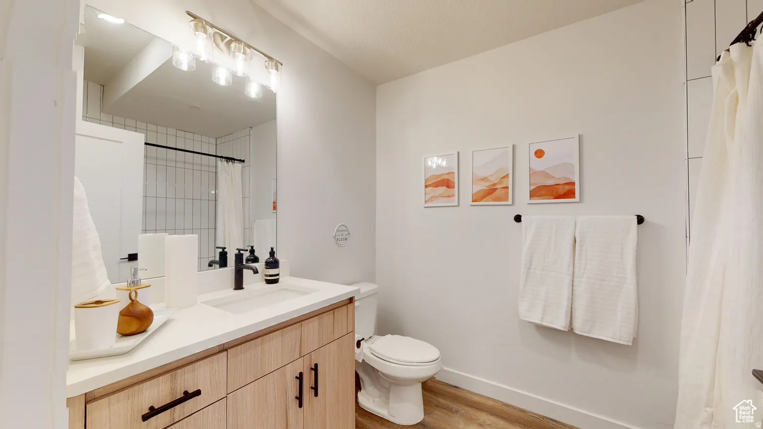 Bathroom with vanity, light wood-style flooring, and a shower with curtain