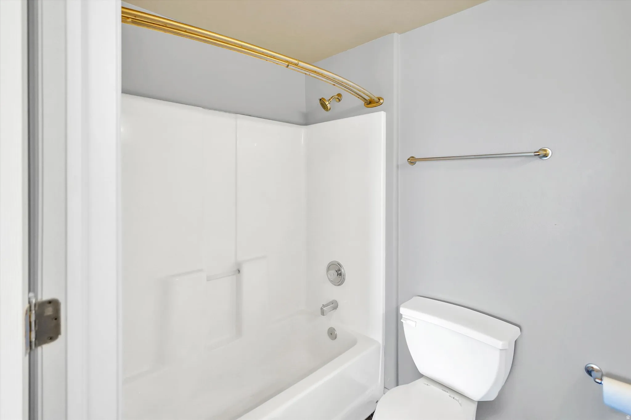Bathroom featuring toilet and washtub / shower combination