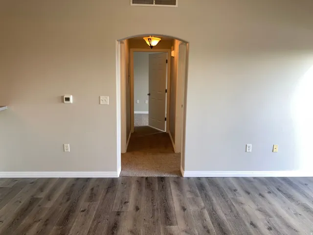 Wood-finish flooring throughout the main area, complemented by light-toned wall paint and white baseboards