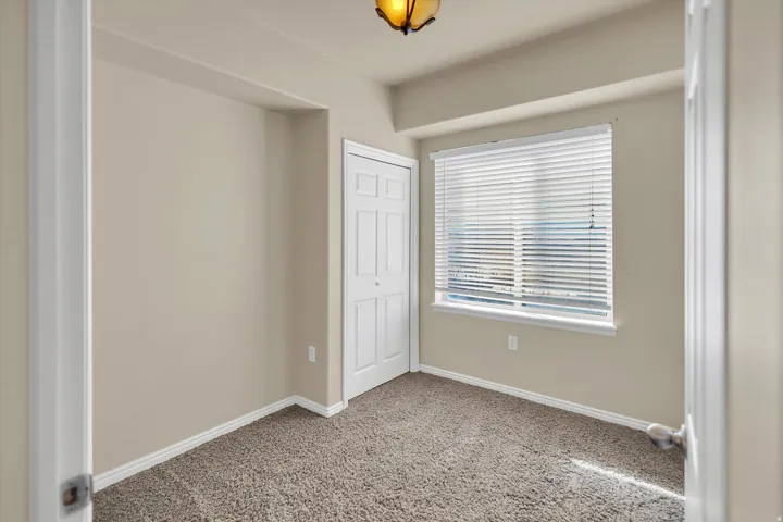 Unfurnished bedroom featuring light carpet and a closet