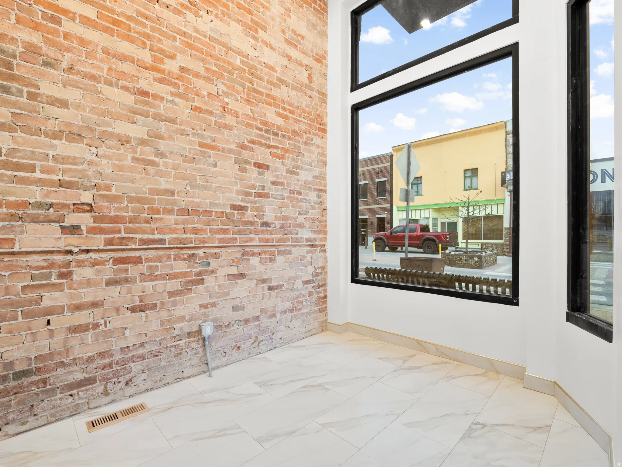 Spare room with brick wall and light marble finish flooring