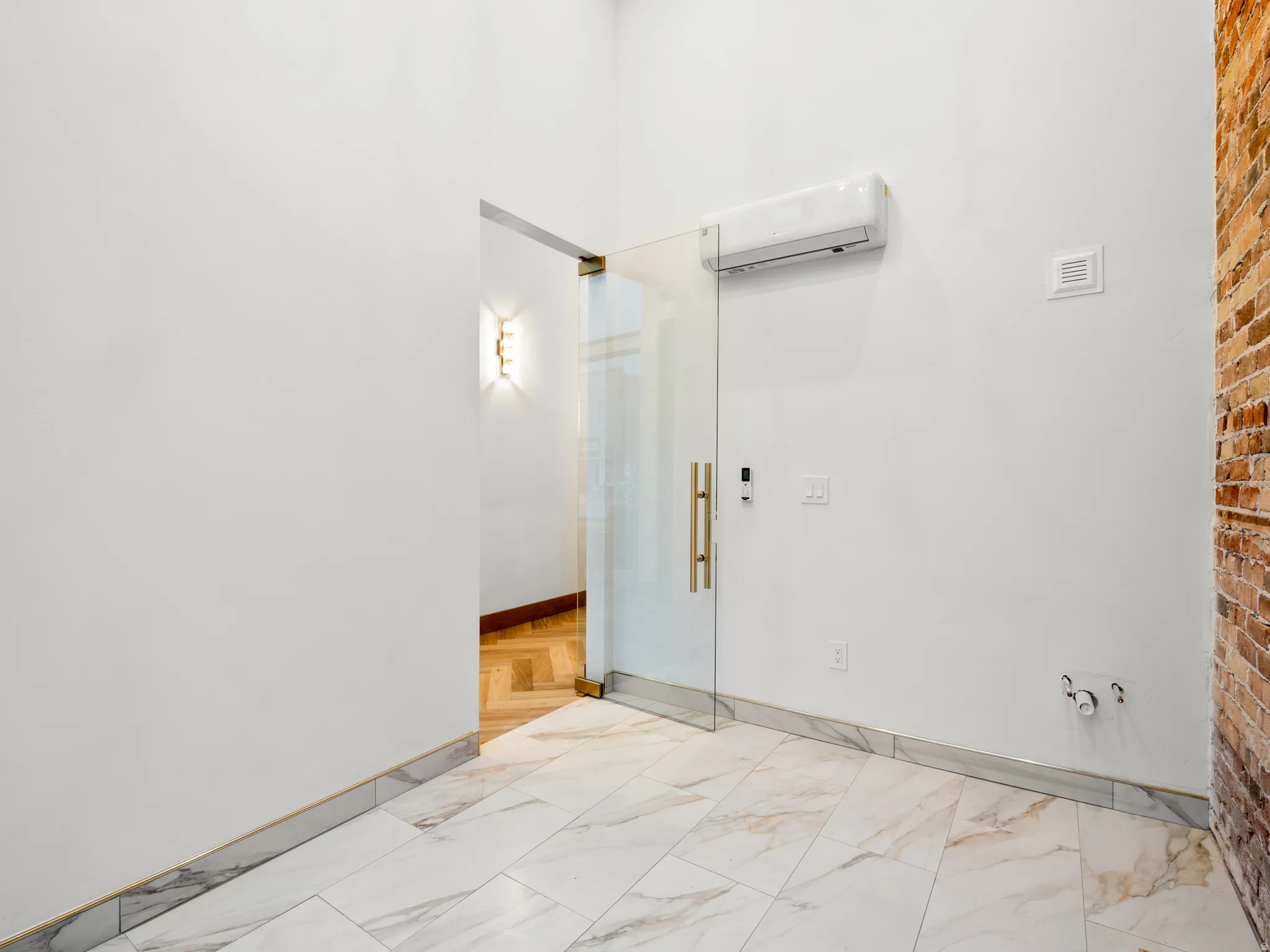 Spare room with a mini split for heating / cooling and light marble finish floors