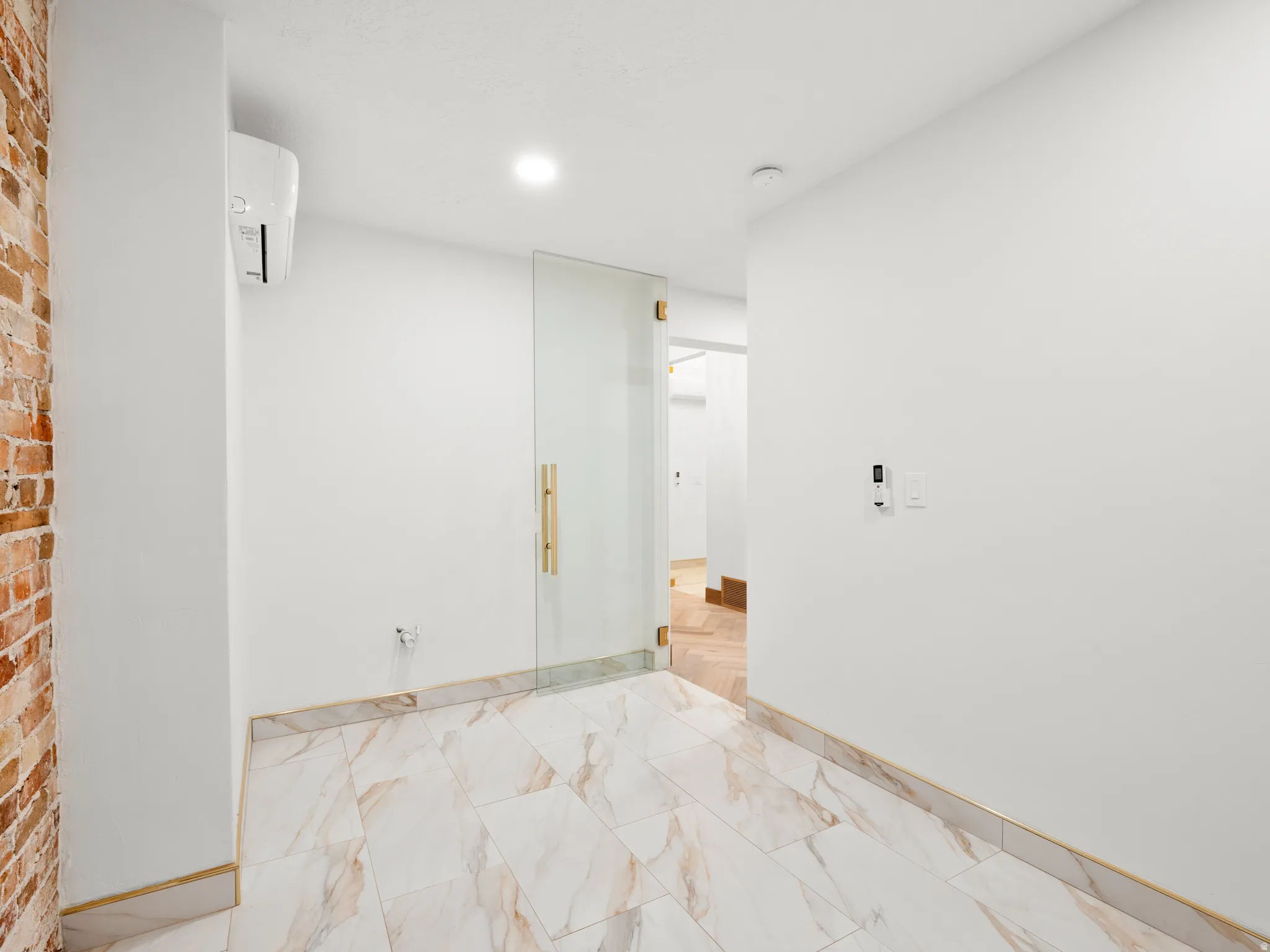 Unfurnished room with a mini split for heating / cooling, recessed lighting, and light marble finish floors