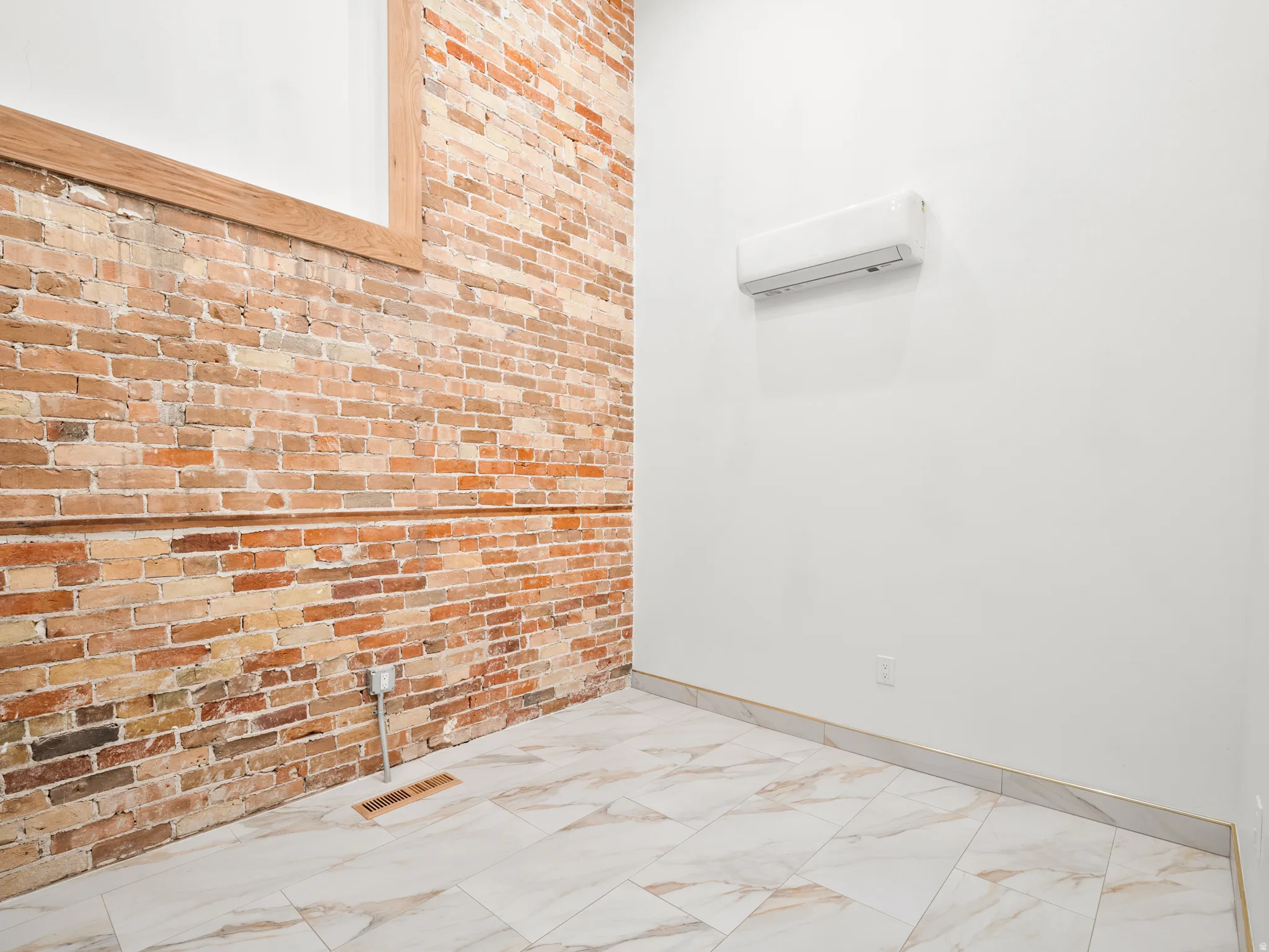 Bathroom with brick wall and a wall mounted mini split