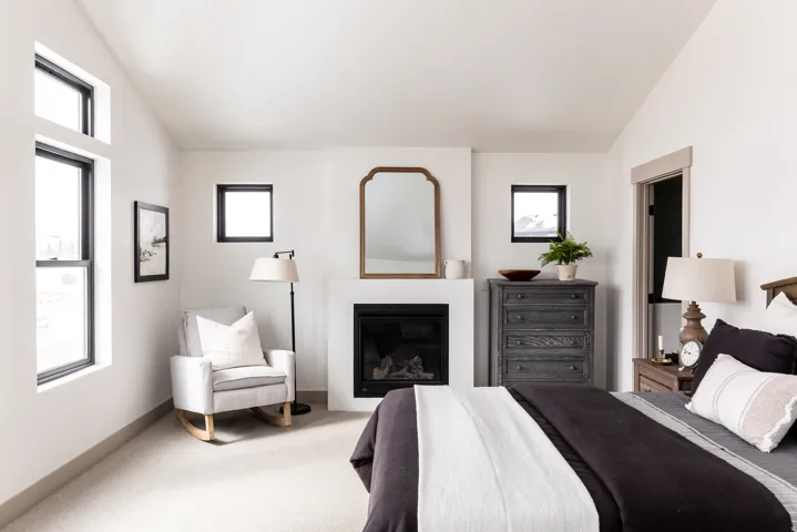 Bedroom with lofted ceiling, a glass covered fireplace, and carpet floors