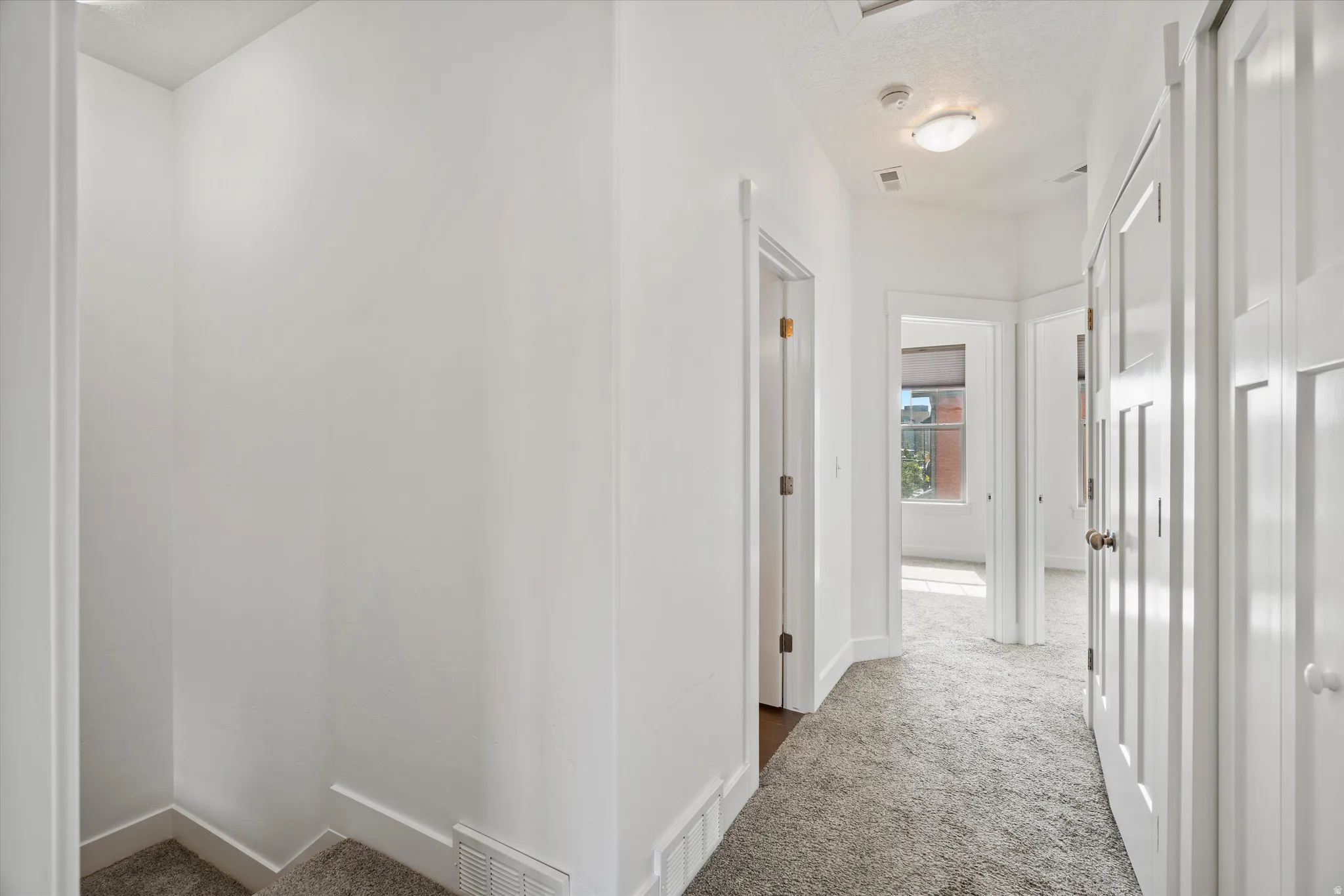 Hallway featuring light gray carpet, white walls, white trim, recessed lighting, and a flush mount light fixture