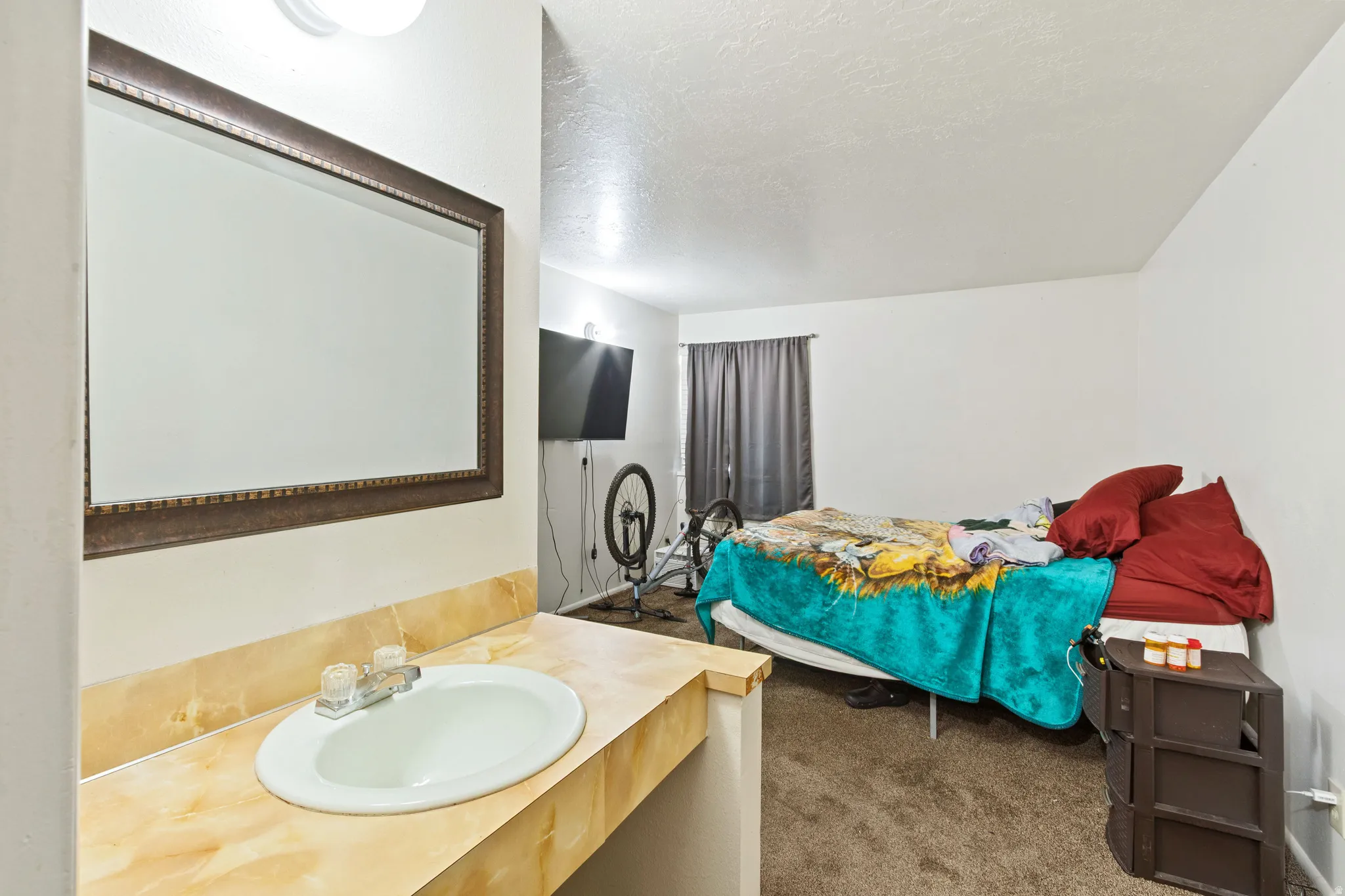 Bathroom featuring vanity, dark colored carpet, and a textured ceiling