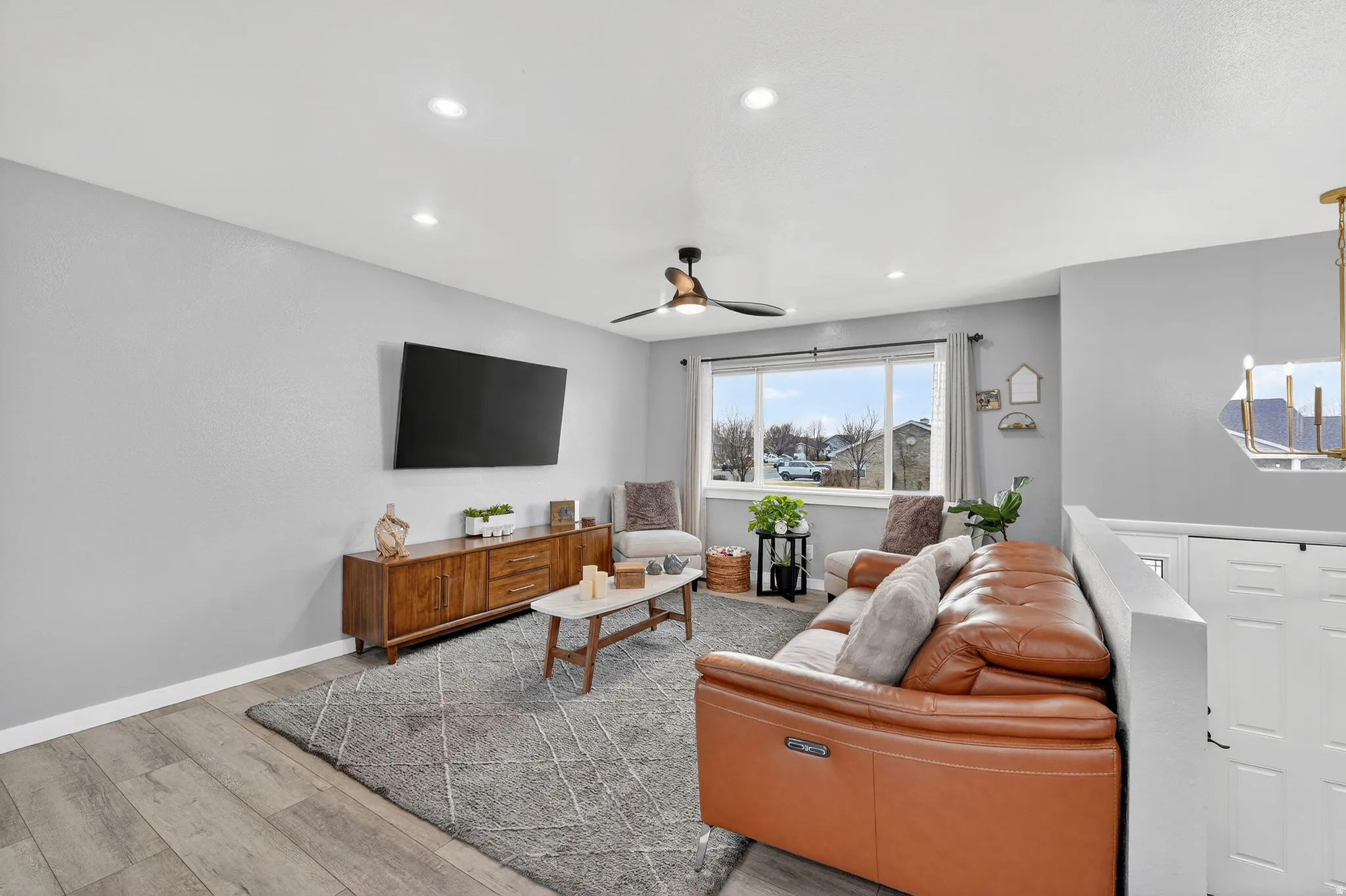 Living room featuring light wood-style flooring, recessed lighting, and a ceiling fan