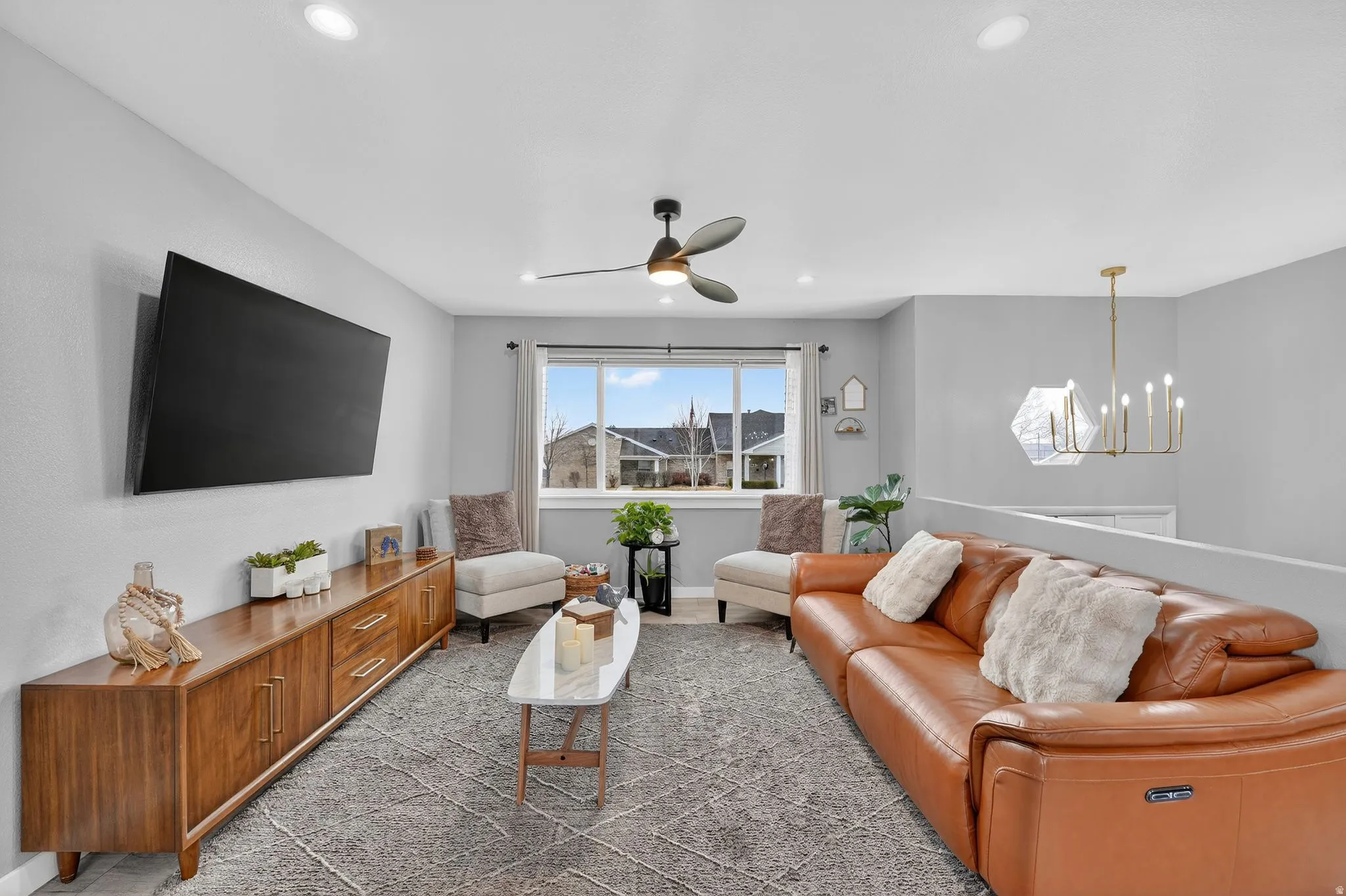 Living area featuring a ceiling fan and a chandelier