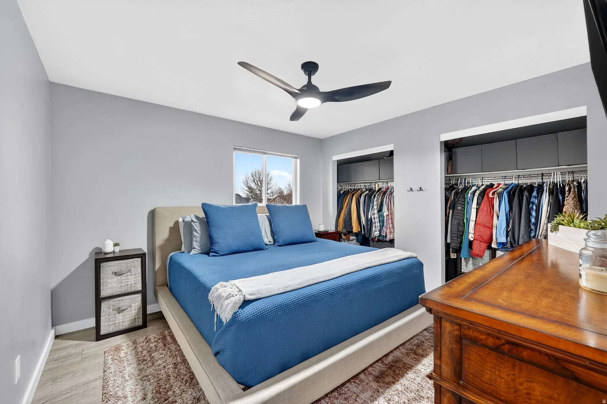 Bedroom with a ceiling fan, multiple closets, and light wood finished floors