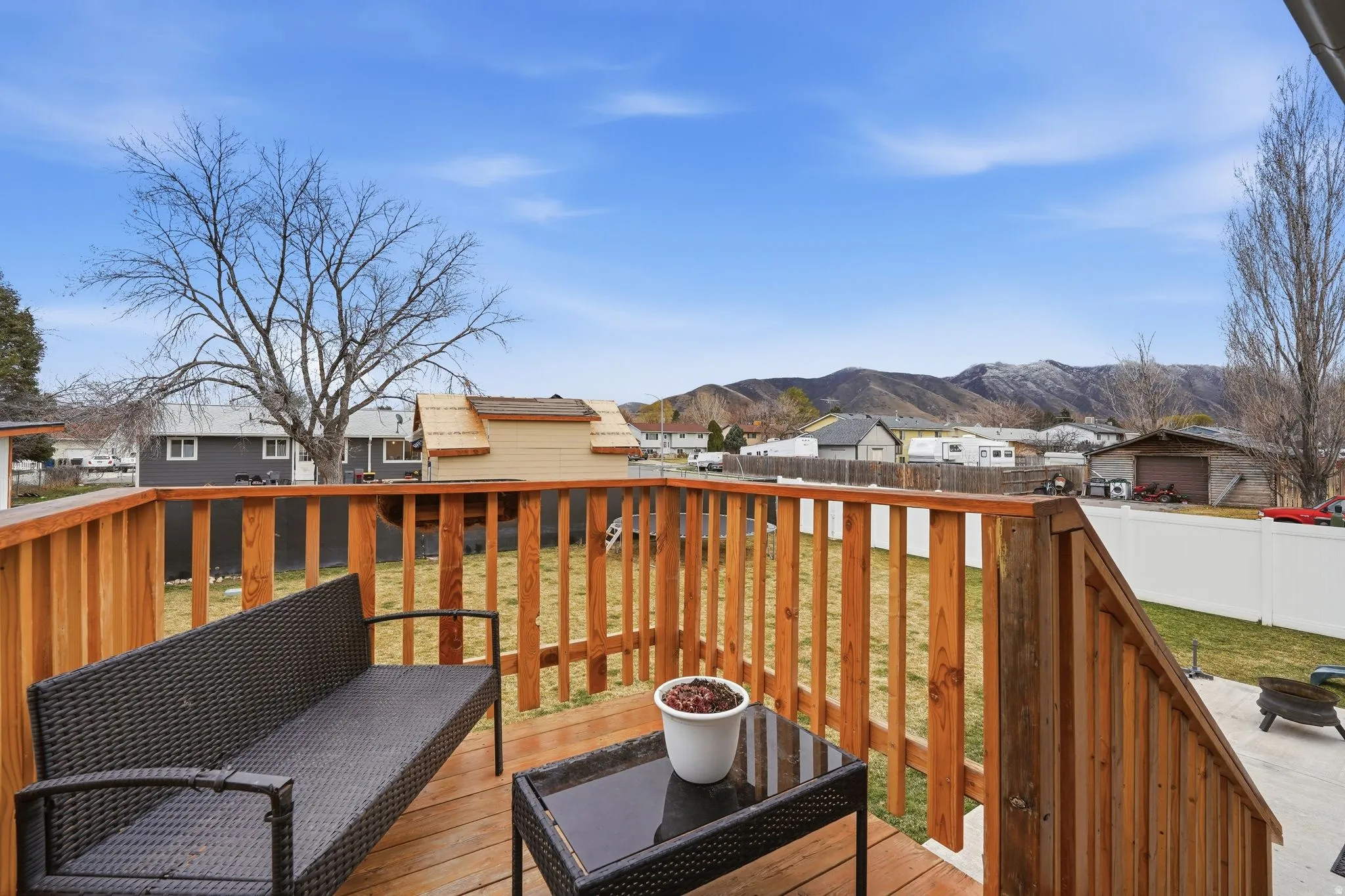 Wooden terrace with a residential view, a fenced backyard, and a mountain view