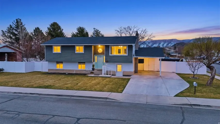 Bi-level home featuring concrete driveway, a chimney, and a mountain view