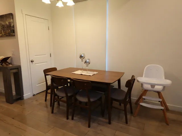 Dining space with wood-type flooring and suspended lighting