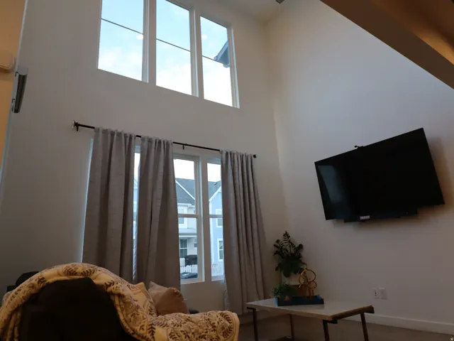 Living room featuring a high ceiling and wood finished floors