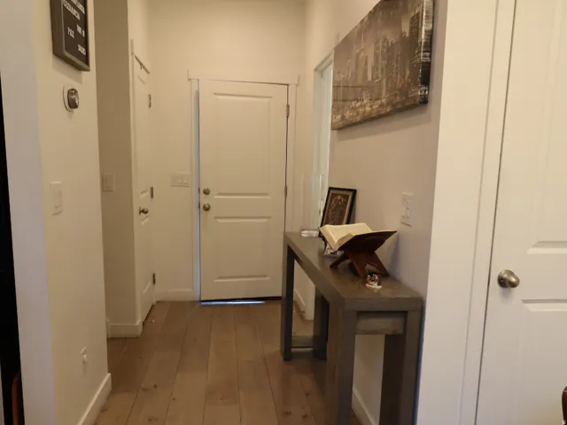 Hallway featuring light wood-type flooring and baseboards