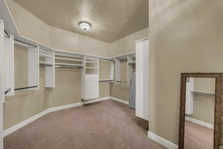 Walk in closet featuring light colored carpet