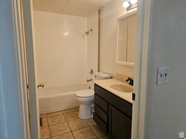 Full bath featuring vanity, light tile patterned floors, and bathtub / shower combination