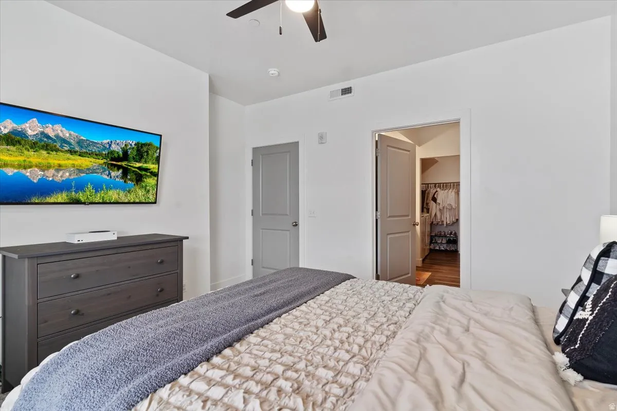 Bedroom with a ceiling fan and a walk in closet