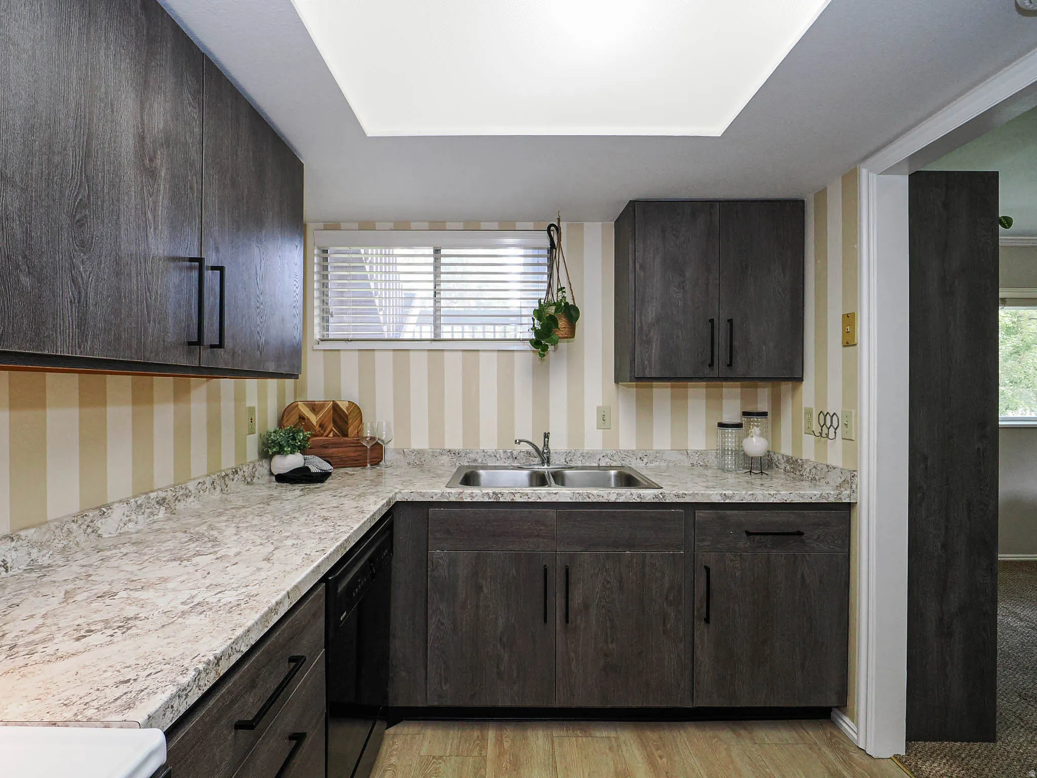 Kitchen with dark wood finish cabinets, light countertops, and dishwasher