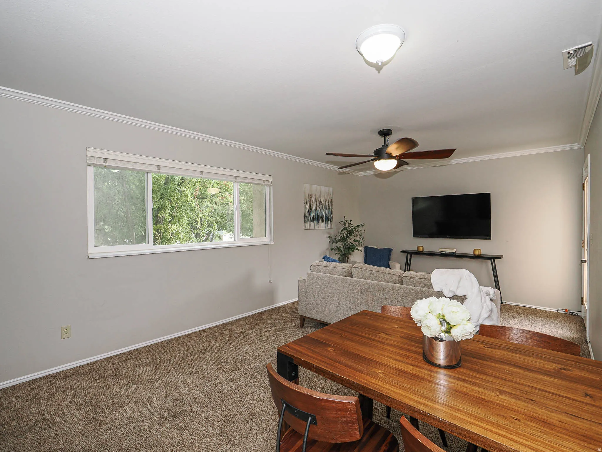Dining room featuring carpet floors, ceiling fan, and crown molding
