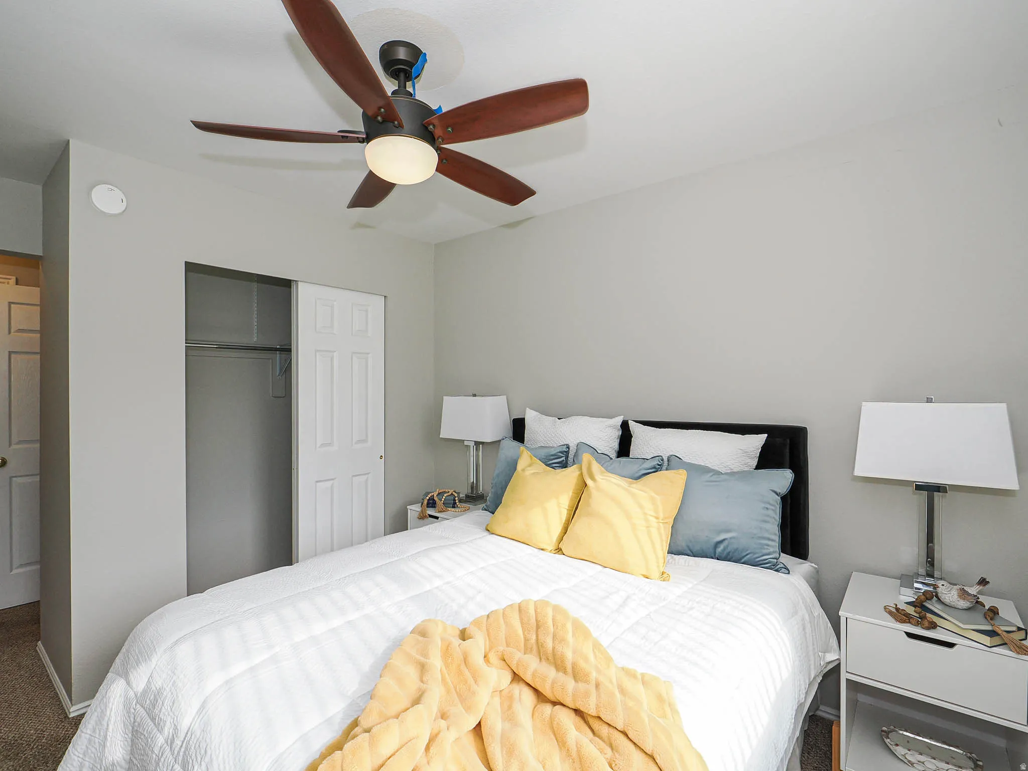Bedroom with a closet, a ceiling fan, and carpet flooring