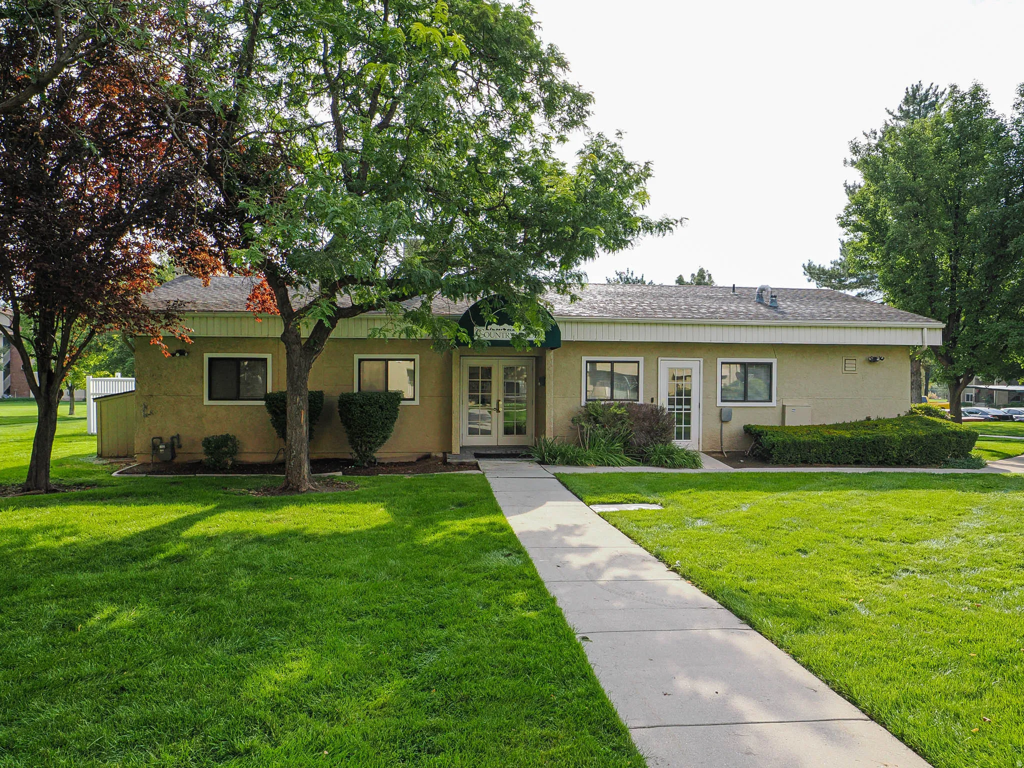 Ranch-style house with french doors, a front lawn, a shingled roof, and stucco siding