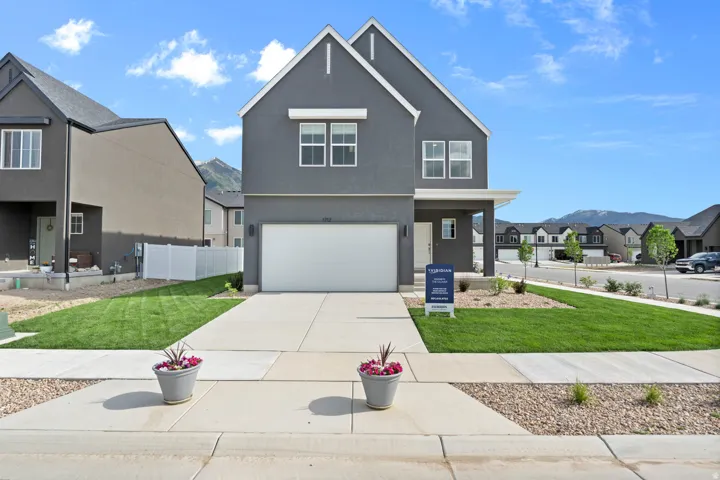View of front facade with a residential view, stucco siding, an attached garage, and concrete driveway