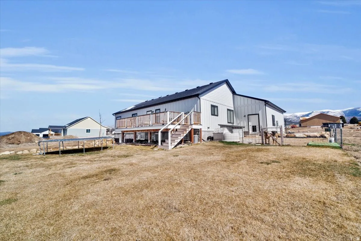 Back of property featuring a trampoline and a deck