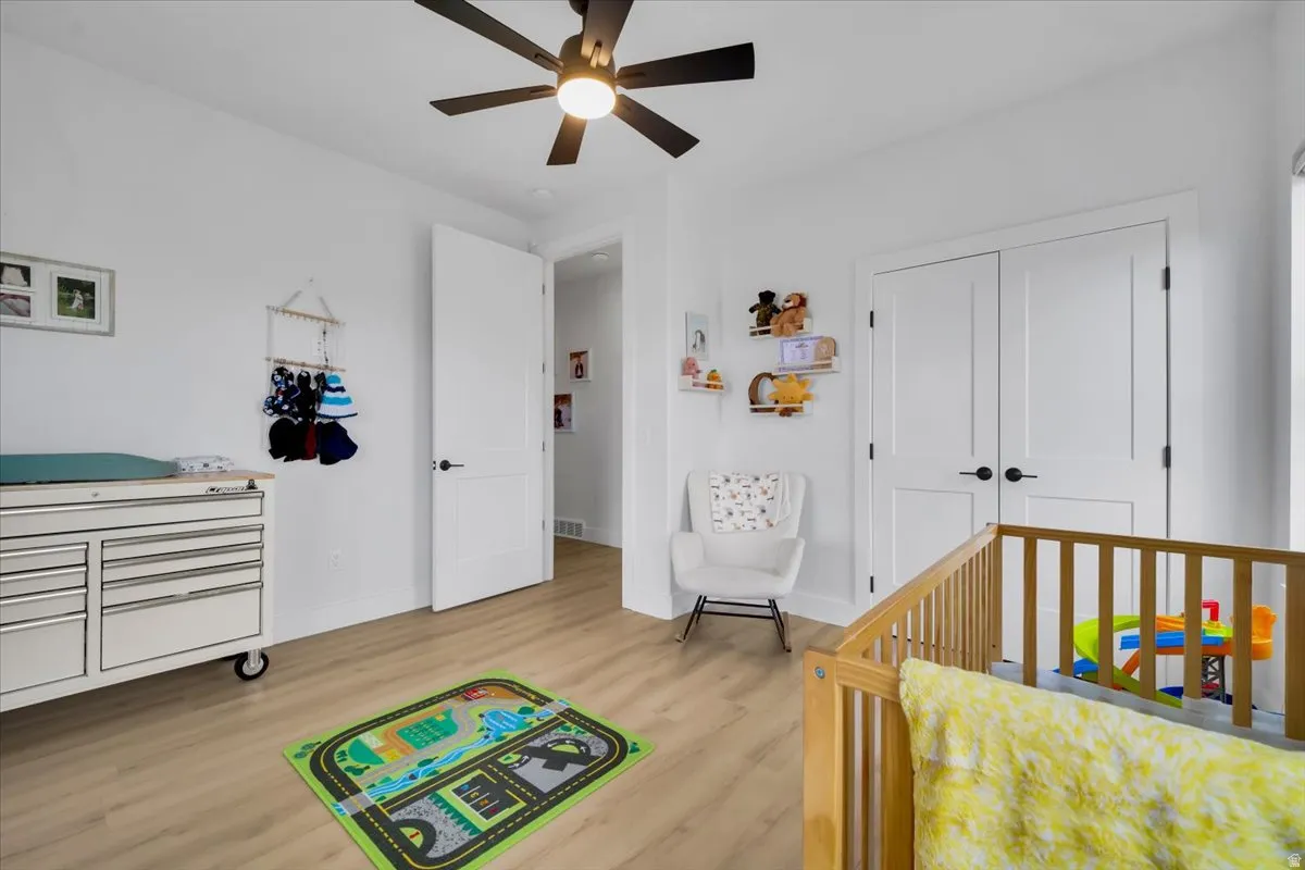Bedroom featuring light wood-type flooring, a closet, and a ceiling fan