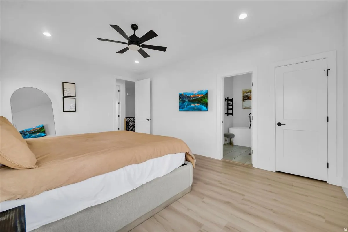 Bedroom featuring light wood-type flooring, a ceiling fan, recessed lighting, and ensuite bath