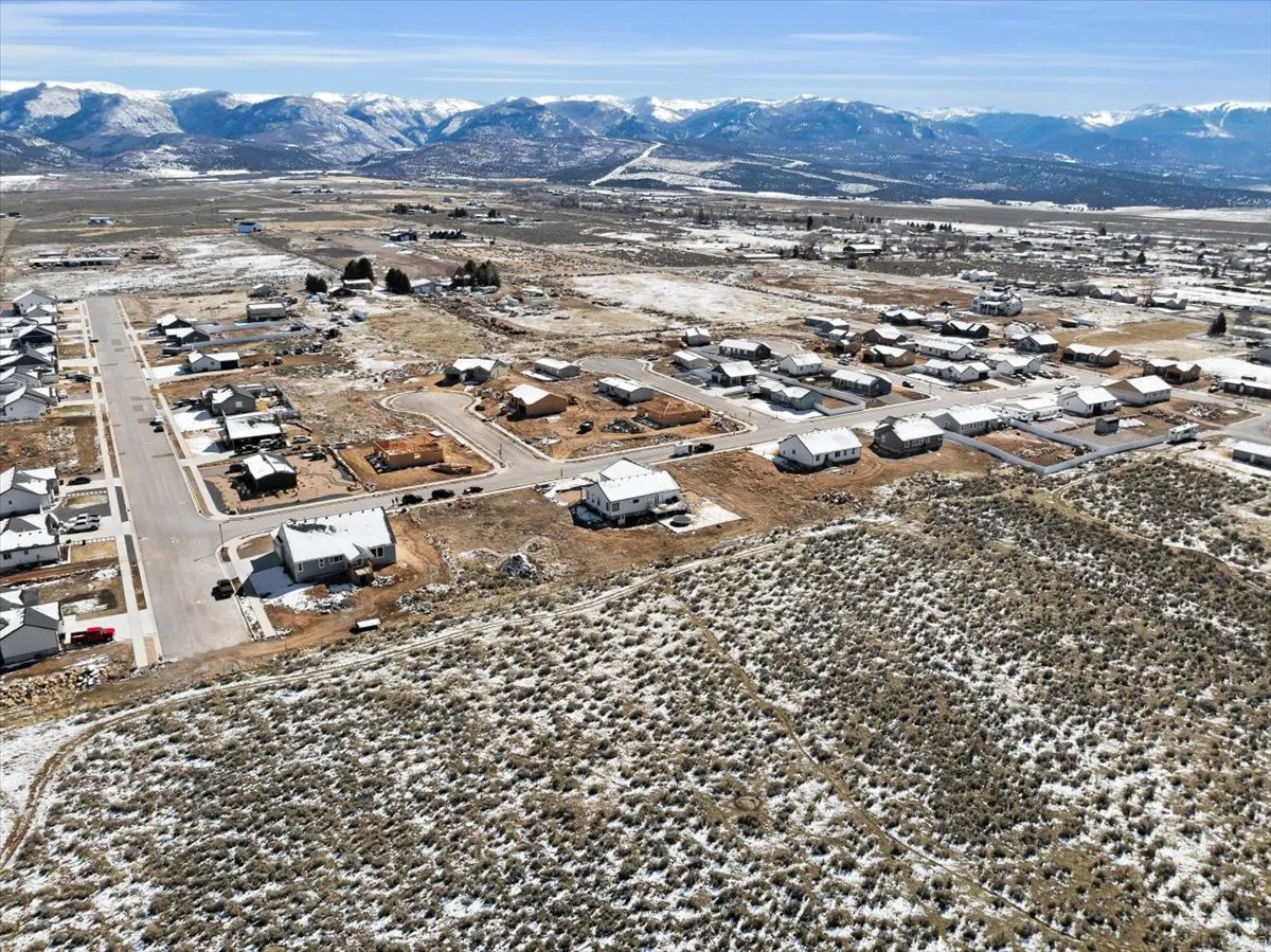 Aerial view of property's location with nearby suburban area and a mountain backdrop