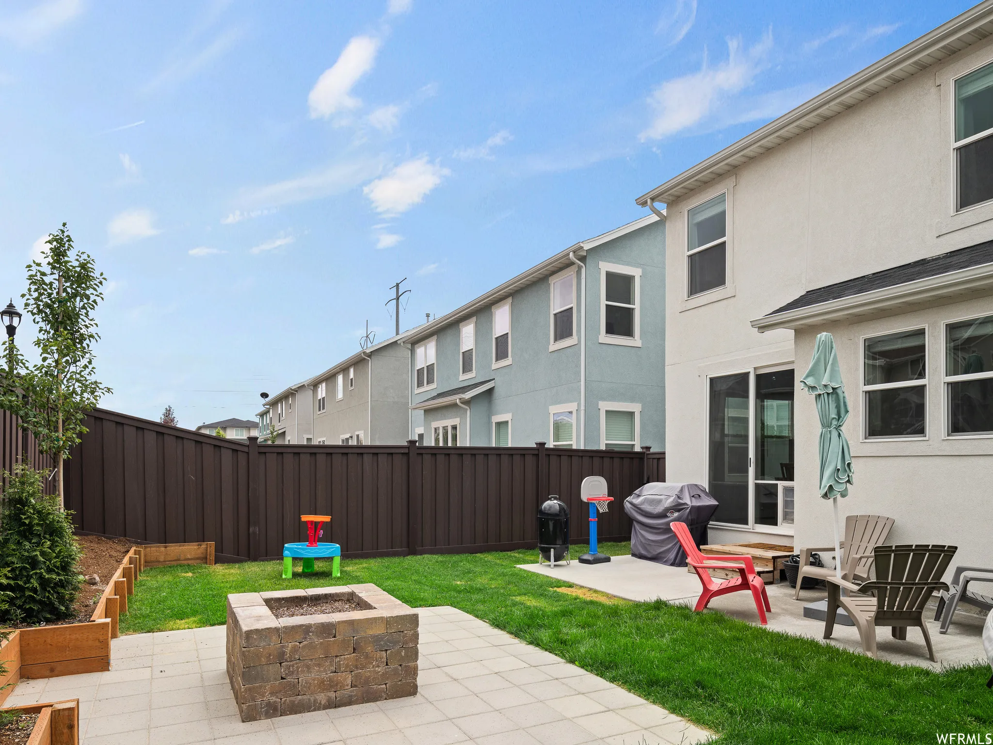 Fenced backyard featuring an outdoor fire pit, a patio, and a grill