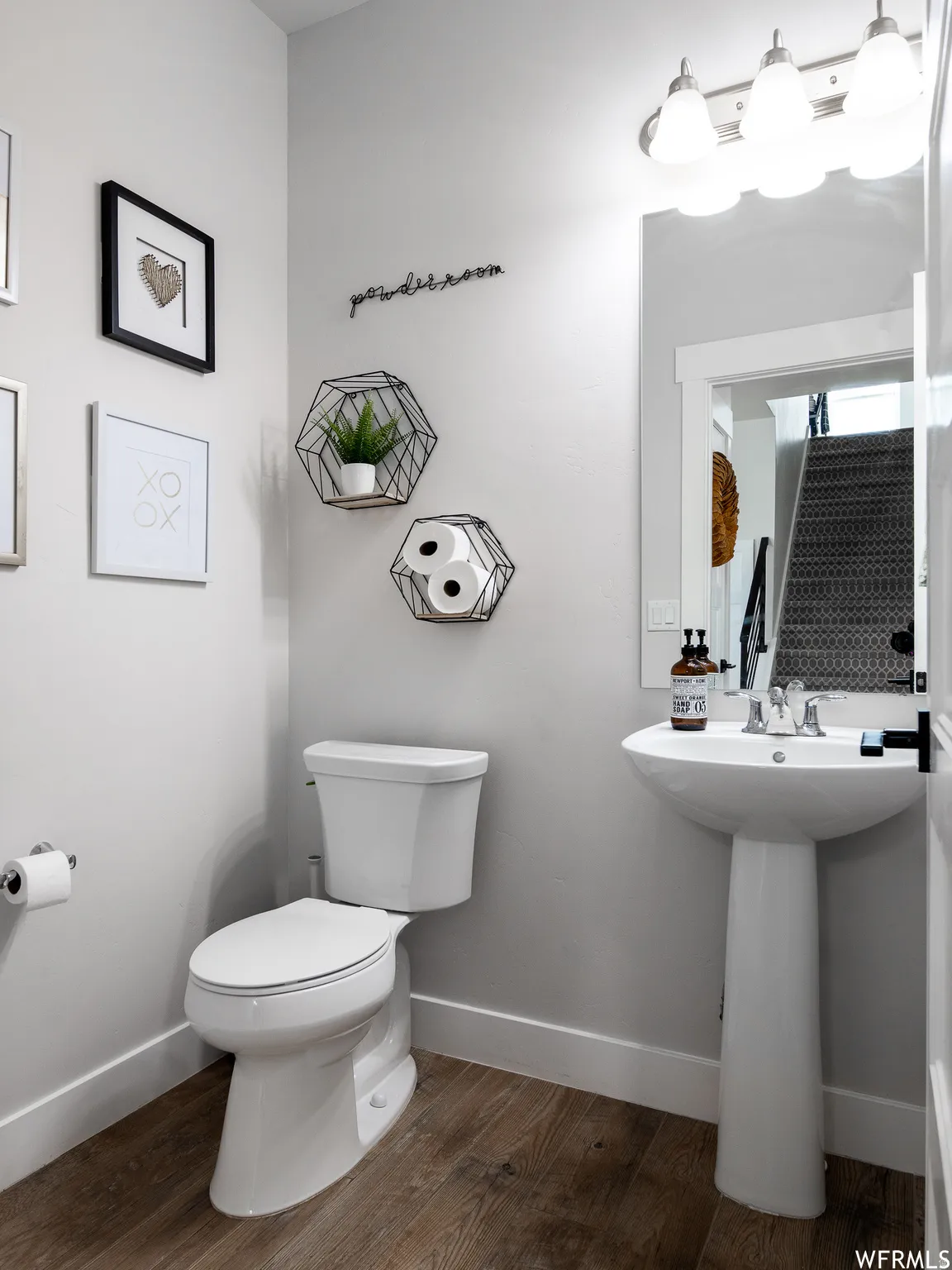 Half bath with dark wood-style flooring and toilet
