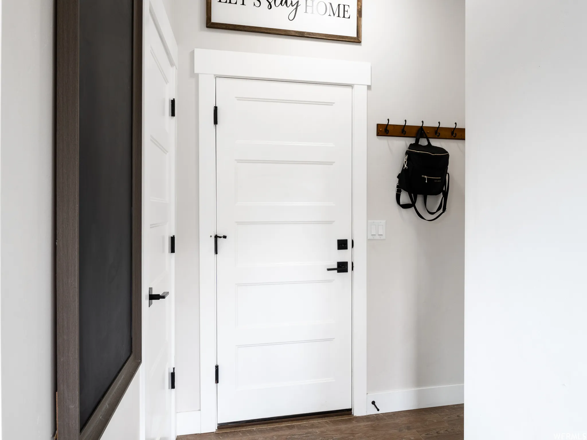 Doorway featuring baseboards and wood finished floors