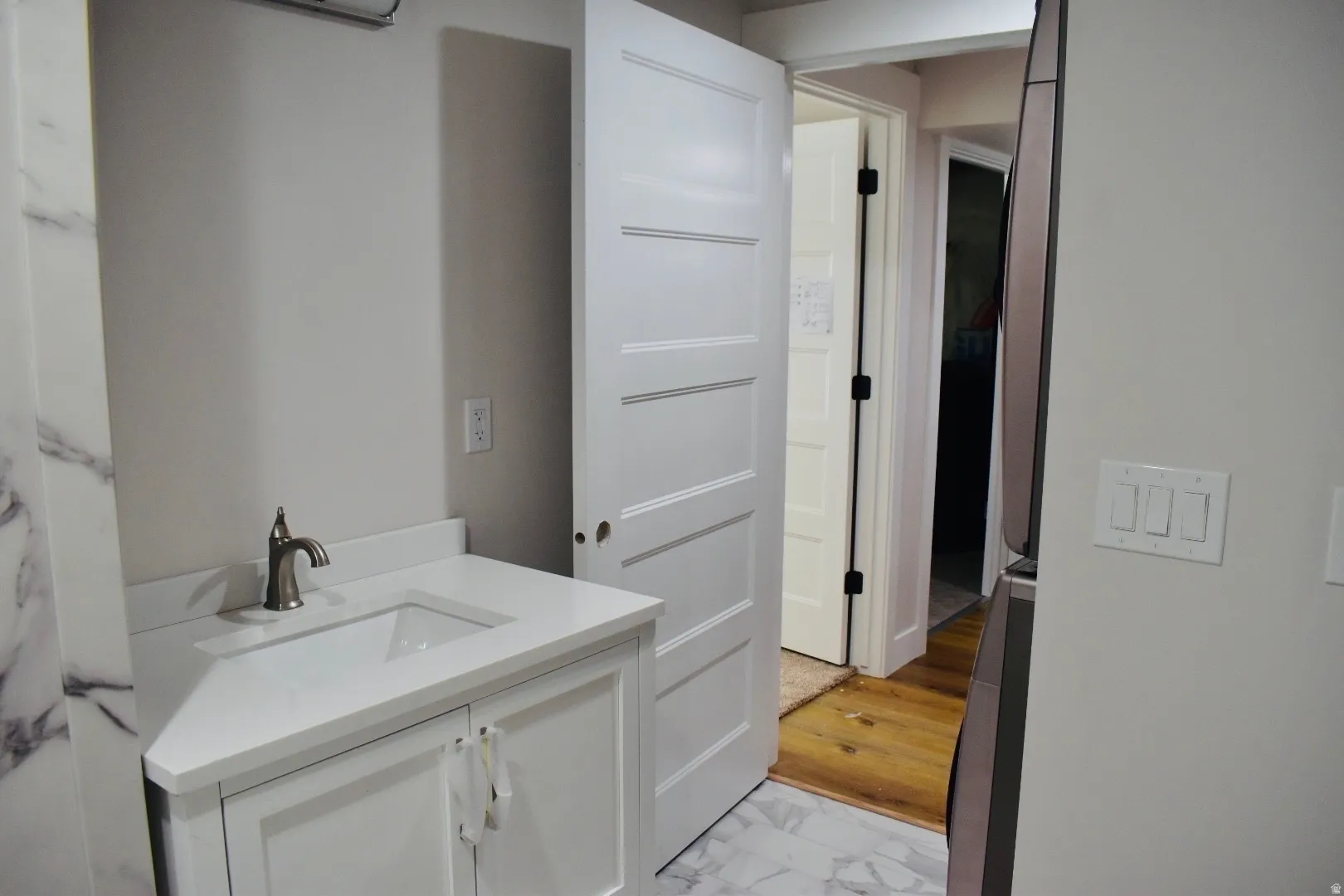 Bathroom with vanity and light marble finish flooring